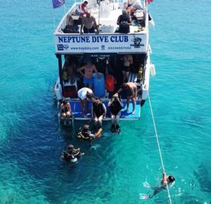 卡斯Neptune Dive Club的一群人坐在船上