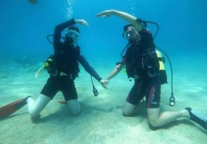 卡斯Neptune Dive Club的两个穿着潜水装备的人站在水中