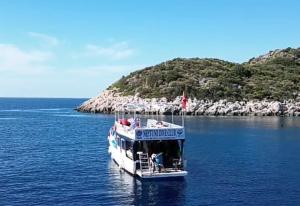 卡斯Neptune Dive Club的水中有一艘白色小船和一座岛屿