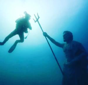 卡斯Neptune Dive Club的一名男子和一名女子在水中拿着长矛