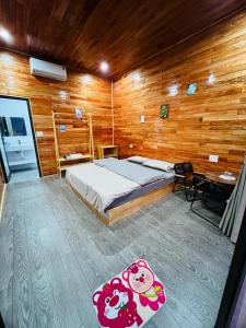 a bedroom with a bed and a wooden wall at Amy Homestay Mộc Châu in Bản Àng