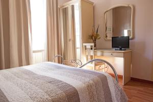 1 dormitorio con cama, espejo y TV en Hotel Adriano, en Turín