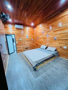 a bedroom with a bed in a wooden wall at Amy Homestay Mộc Châu in Bản Àng