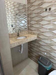a bathroom with a sink and a trash can at Área de lazer L&J in Barretos