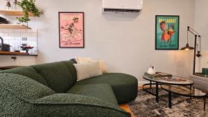 a living room with a green couch and a table at Prospect Cottage Ballarat in Ballarat