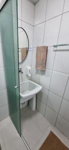 un baño con lavabo y espejo en Diamantino, en Praia Grande