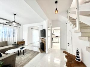 STAY Cavo Bay Villa في بروتاراس: غرفة معيشة بها أريكة وطاولة