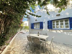 STAY Cavo Bay Villa في بروتاراس: طاولة وكراسي في فناء المنزل