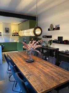 a dining room table with a vase of flowers on it at City Penthouse with 3 floors , Super King Bed , with secret garden in Birmingham