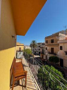 a wooden bench sitting on the balcony of a building at Terrasini downtown City Life in Terrasini