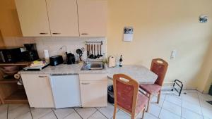 プラウ・アム・ゼーにあるMeenaのキッチン(シンク付)、カウンター(椅子2脚付)