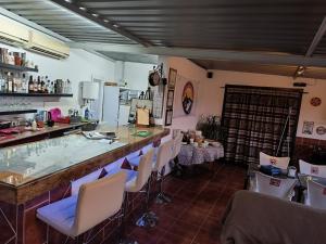 a restaurant with a bar with chairs and tables at 2 Wheels Granada Motocamp in Vallequemado