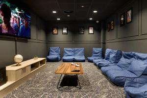 a living room with blue couches and a tv at For Students Only - Studio Rooms in Reading in Reading
