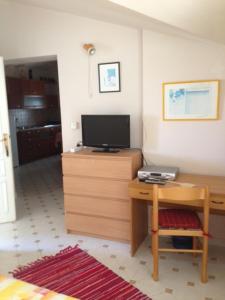 a room with a desk with a tv and a table with a desk at Apartments Bellavista in Rovinjsko Selo