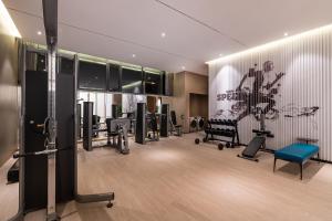 - une salle de sport avec des tapis de course et des chaises dans l'établissement 青岛崂山石老人会展中心桔子水晶酒店, à Qingdao