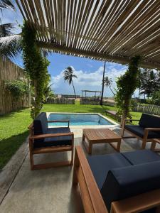 un patio trasero con piscina y pérgola de madera en Casa Mar - Os Navegantes, en Amontada