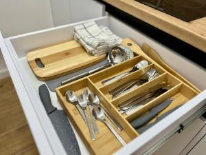 a kitchen drawer with a wooden tray and utensils at Crosshill apartments in Međugorje