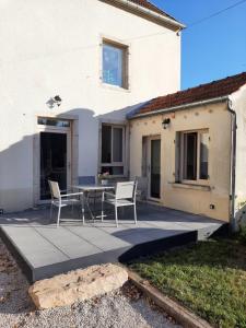 a patio with two chairs and a table in front of a house at Maison Indépendante in Soissons-sur-Nacey