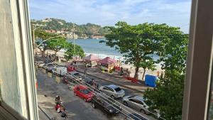 a view from a window of a street with cars parked at Pousada da Tia Penha in Engenho Novo +17 photos