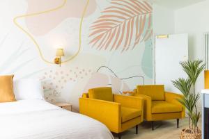 a bedroom with a bed and two yellow chairs at The Beach House - Pool & Spa in Scarborough