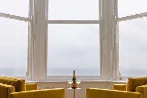 a room with three windows and a bottle of wine at The Beach House - Pool & Spa in Scarborough +51 photos