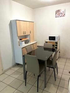 a kitchen with a table and chairs and a refrigerator at Location courte durée T2 avec terrasse à Montpellier in Montpellier