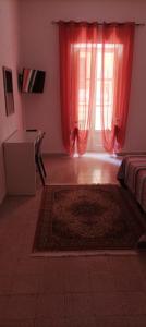 un soggiorno con tenda rossa e finestra di Penelope a Agrigento 1 altra foto
