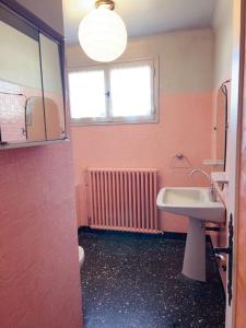 a bathroom with a sink and a toilet and a window at 住在巴黎 in Bondy