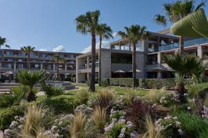 - une vue sur l'extérieur d'un bâtiment avec des palmiers dans l'établissement Atlantica Kalliston Resort - Adults Only, à Stalós