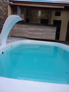 uma piscina com uma fonte de água numa casa em Area de Lazer L&J 2 em Barretos