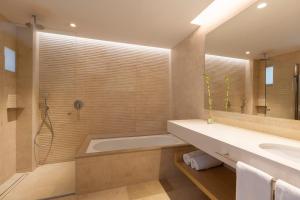 a bathroom with a tub and a sink at Hipotels Barrosa Park in Chiclana de la Frontera