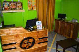 a room with a wooden desk with a green wall at Luxury Everest Hotel in Trincomalee
