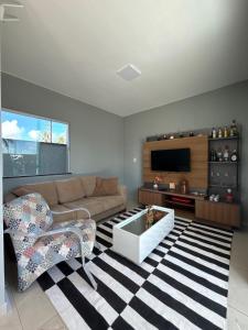 Una sala de estar con un sofá y un televisor. en Casa Por Do Sol, en Salinópolis