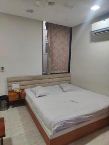a bedroom with a large bed with a window at Hotel Paras in Udaipur