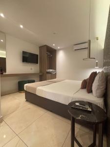 a bedroom with a bed with a table and a tv at Tuck Inn in Larnaca