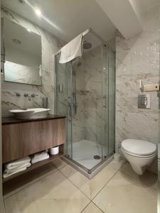 a bathroom with a shower and a toilet and a sink at Tuck Inn in Larnaca