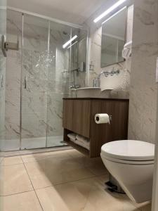a bathroom with a shower and a toilet and a sink at Tuck Inn in Larnaca