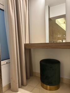 a bathroom with a mirror and a green stool at Tuck Inn in Larnaca