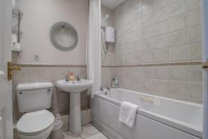 a bathroom with a toilet and a sink and a tub at The Well - 3 bedroom apartment in Motherwell +34 photos