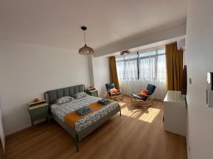 Un dormitorio con una cama y una ventana grande. en Yaio Penthouse, en Agigea