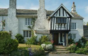 an old white house with two chimneys at Spacious Cottage in Dartmoor in Hennock