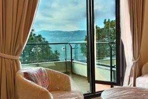 a room with a balcony with a chair and a window at 1 Bed Luxury Studio with Mountain View in Murree