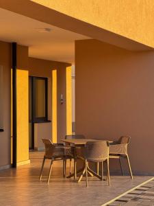 a table and chairs in a building with yellow walls at Salt Hill Premium Apartments in Egerszalók