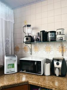 encimera de cocina con microondas y tostadora en Casa Ampla - Climatizada - 1 suite-2 quartos-churrasqueira, en Foz do Iguaçu
