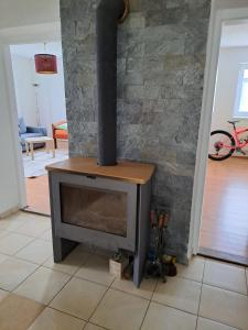a wood stove in a living room with a brick wall at Chalupa Klára in Dvorec +4 photos