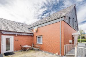 a red brick building with a bench on a patio at Kompaktes Studiozimmer mit Pantryküche und Fußbodenheizung in der Nähe der Messe Dusche und WC werden gemeinschaftlich genutzt in Hannover