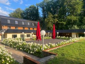 a garden with red umbrellas and white flowers at Schössersmühle in Eisenberg
