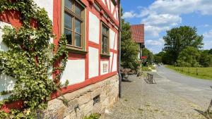 a red and white building with plants on the side of it at Alte Pletschmühle in Homberg