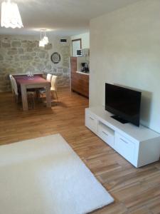 a living room with a flat screen tv on a white cabinet at Apartment Peky in Rab