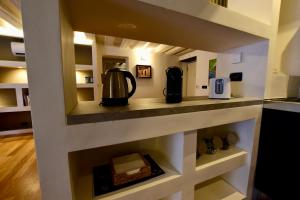 a kitchen with a shelf with a coffee maker on it at Luxury Cernaia Home alloggio di charme nel Centro Storico in Genoa